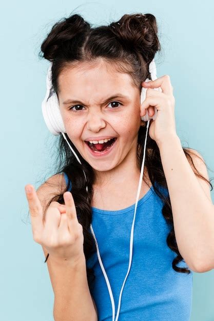 Niña Sonriente Escuchando Música Rock En Los Auriculares Foto Gratis