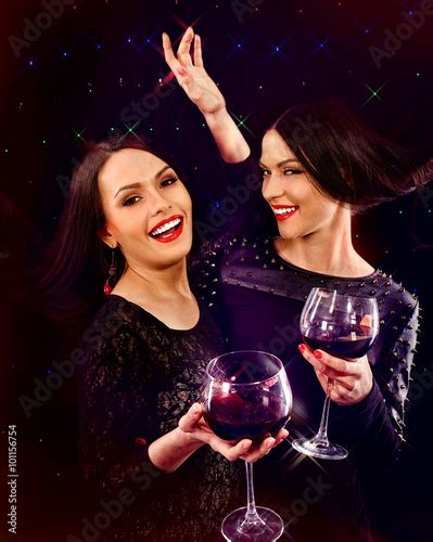Two Sexy Lesbian Women Drinking Red Wine And Joying On Black Background