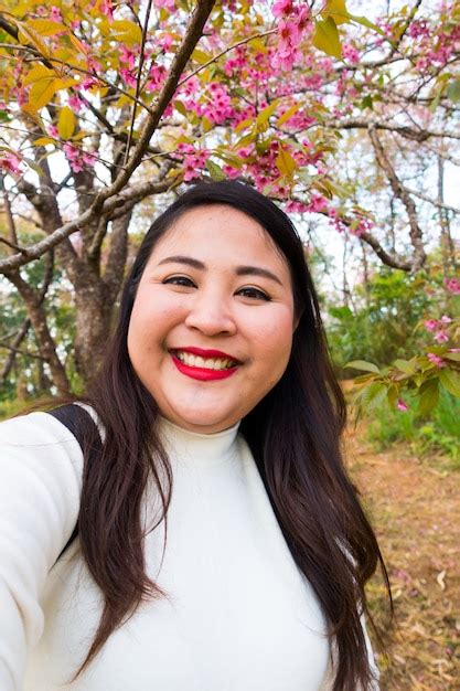 mujeres asiáticas con cabello largo y negro toman selfie sonriendo retrato con flores foto