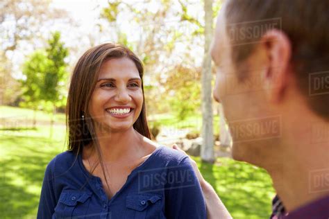 Mixed Race Couple In A Park Looking At Each Other Stock Photo Dissolve