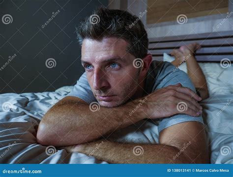 Young Sad And Depressed Sleepless Man Lying On Bed Worried And