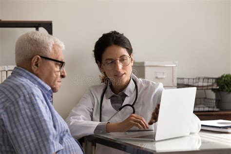 Female Doctor Consult Senior Male Patient Using Computer Stock Image