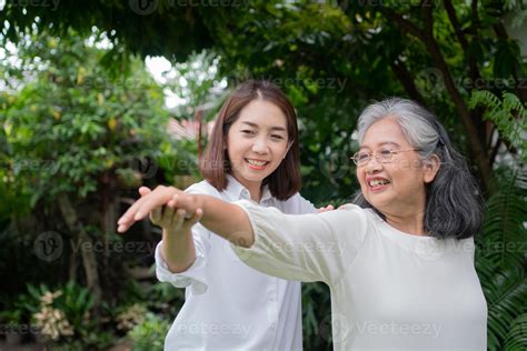 an old elderly asian woman and exercise in the backyard with her daughter concept of happy