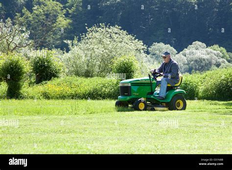 Elderly Man Mowing The Lawn On A John Deere Sit On Lawnmower Bengel