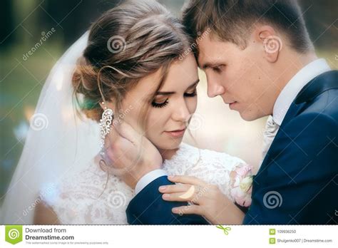 Жених и невеста в платьях свадьбы на естественной предпосылке Сногсшибательная молодая пара