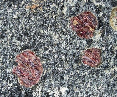 Four Rocks With Red And Black Paint On Them