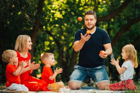 Padre Malabares Con Naranjas Frente A Su Familia Foto Gratis
