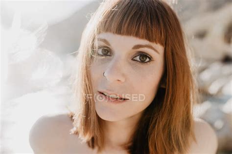 Spots Of Bright Sunlight In Front Of Naked Woman Looking At Camera Against Cloudless Sky In