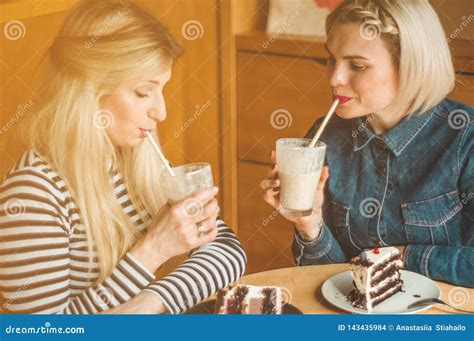 Two Happy Women Sitting In A Cafe And Taking Selfies On The Phone