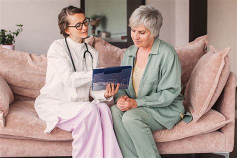 Female Nurse Doctor Caretaker Assisting Happy Senior Grandma Healthcare Homecare Concept Stock