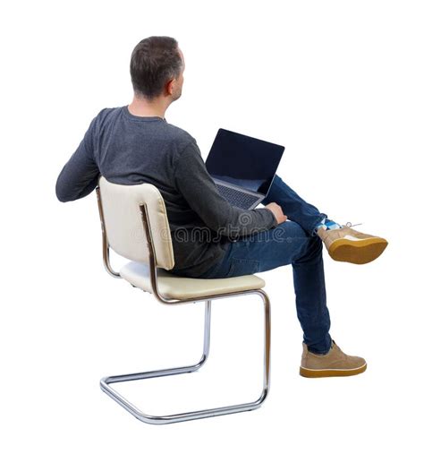 Back View Of A Man Who Sits On A Chair With A Laptop Stock Photo