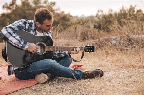 Free Photo Man Sitting On Blanket Playing Guitar Playing Guitar