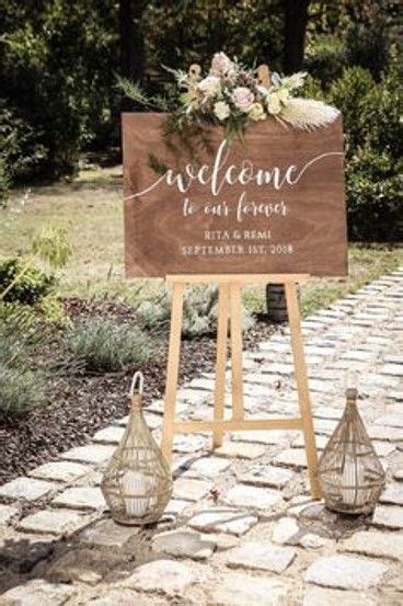 A Welcome Sign With Flowers And Greenery Is Displayed In Front Of A