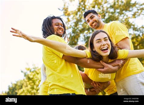 Group Of Young People Together Lifts Laughing Woman For Confidence And