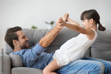 Carefree Excited Child Girl And Her Father Playing Holding Hands