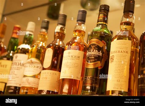 Selection Of Scotch Whisky Bottles On Glass Shelves In Bar Stock Photo