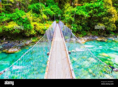 Hanging Bridge Across Pristine Fresh Stream Of Mountain River In