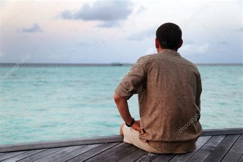 Man Sitting On A Pier Looking Into The Ocean — Stock Photo