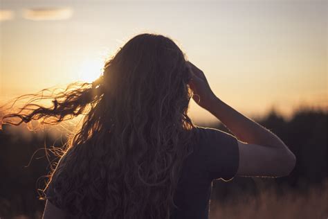 Фото девушки с длинными волосами со спины на закате