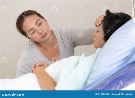Asian Woman Daughter Take Care Of Her Senior Old Mother Patient That Sleeps On Bed In Hospital