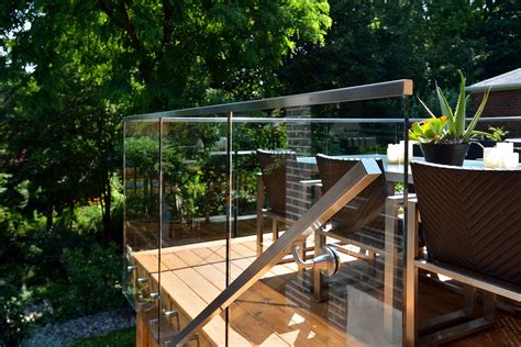 An Outdoor Deck With Glass Railings And Potted Plants