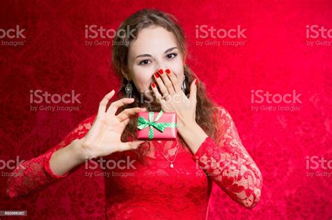 Beautiful Enthusiastic Girl With A Small Gift In A Red Dress Stock