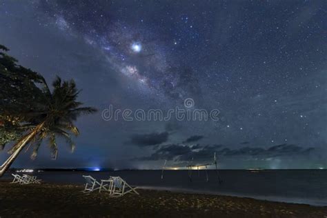 The Milky Way Rises Above The Sea By The Beach At Night Stock Photo
