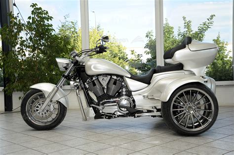 A White Motorcycle Parked In Front Of A Large Window With Lots Of