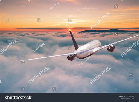 Commercial Airplane Jetliner Flying Above Dramatic Stock Photo