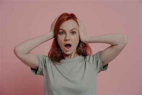 Indoor Shot Of Shocked Scared Woman Keeping Head In Hands Staring At