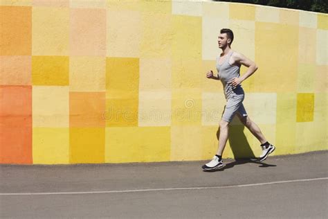Side View Of Man Running Against Bright Wall Stock Photo Image Of