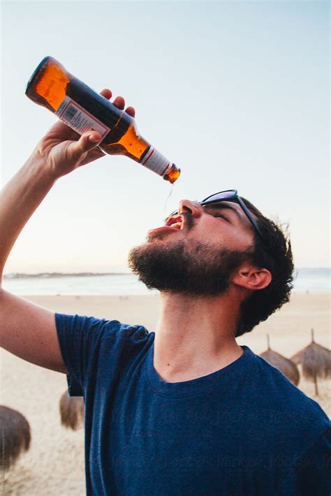 Man Drinking The Last Drop Of His Bottle Of Beer On A Beach Bar By Alejandro Moreno De Carlos