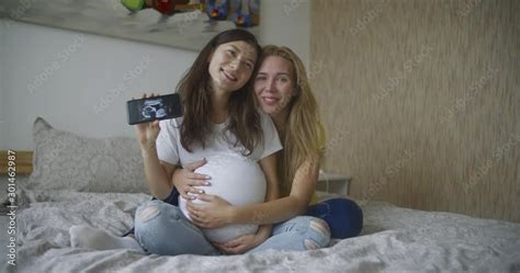 Pregnant Multinational Lesbian Couple Shows At An Ultrasound Image Of