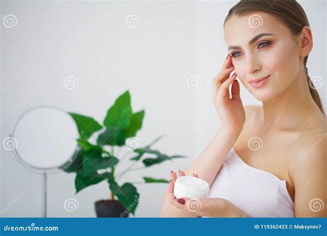 portrait of beautiful woman applying cream on face stock image image of beautiful cheek