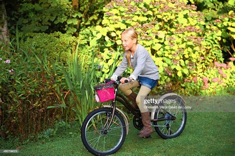Young Girl Riding Bicycle In Garden Photo Getty Images