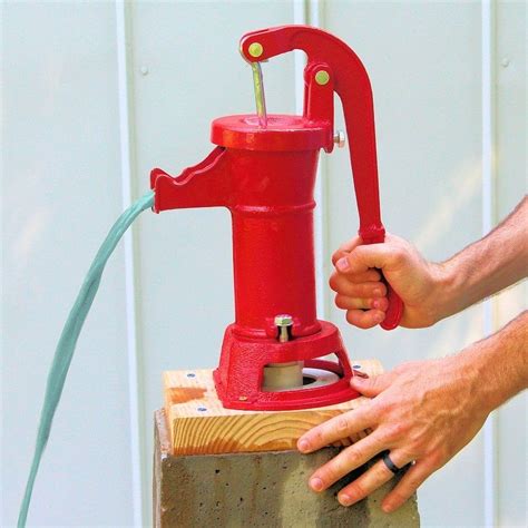 A Man Is Working On A Red Object With A Hose Attached To The Top Of It