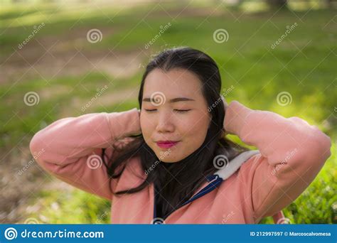 Lifestyle Portrait Of Young Happy And Beautiful Asian Chinese Woman In Pink Sweater Lying On