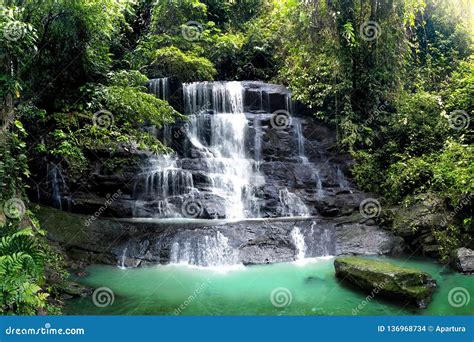 Waterfall Cascade In Tropical Rainforest With Big Rock Cover With Green
