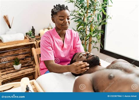 Young Physiotherapist Woman Giving Head Massage To African American Man At The Clinic Stock
