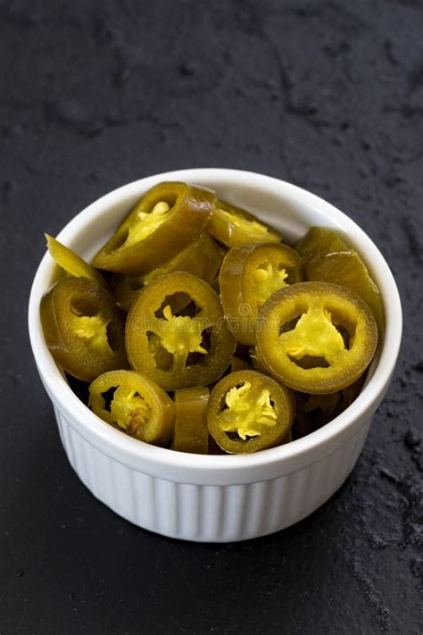 Pickled Sliced Green Jalapeno Peppers In White Bowl Close Up Stock