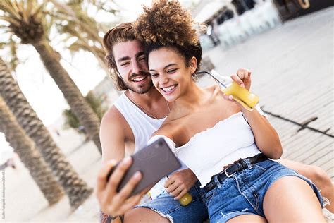 Smiling Couple Making Selfie Outdoors By Stocksy Contributor Guille