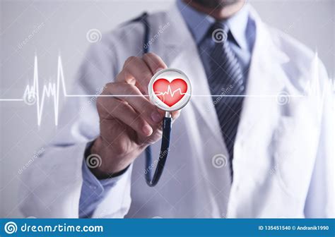 Doctor With Stethoscope Holding Red Heart With Cardiogram Stock Photo