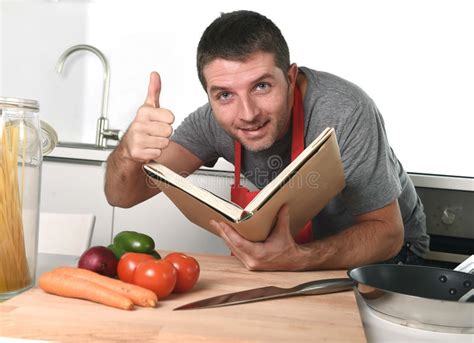 Download and setup play store apk. Young Happy Man At Kitchen Reading Recipe Book In Apron ...