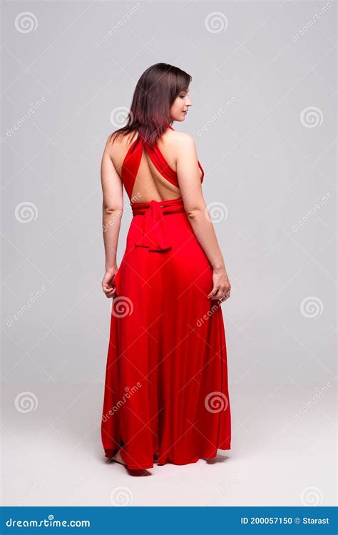 Sexy Frau Im Roten Kleid Im Studio Auf Grauem Hintergrund Stockfoto