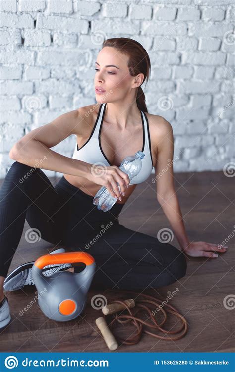Young Fit Woman Drinking Water From Bottle During Workout Stock Photo
