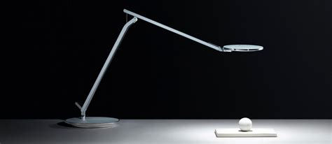 A White Desk Lamp Sitting On Top Of A Table Next To A Small Light Bulb
