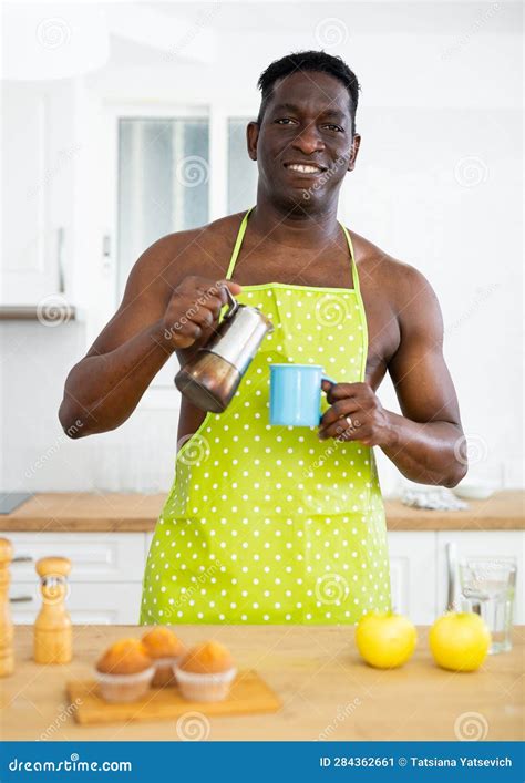 Positive Naked Man In Apron Pouring Coffee Into Cup In Home Kitchen Stock Image Image Of