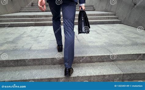 Man In Business Suit Walking Upstairs Holding Briefcase Beginning Of