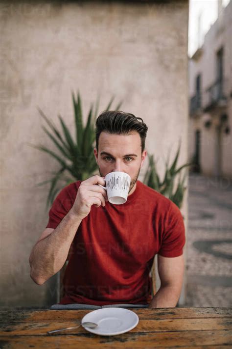 Man Drinking Coffee At Sidewalk Cafe Stock Photo