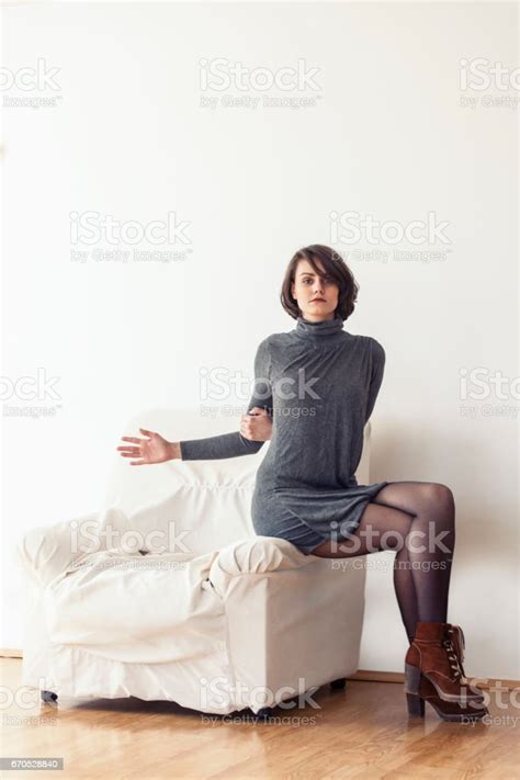 Young Woman Sitting Legs Crossed On Sofa Stock Photo Download Image